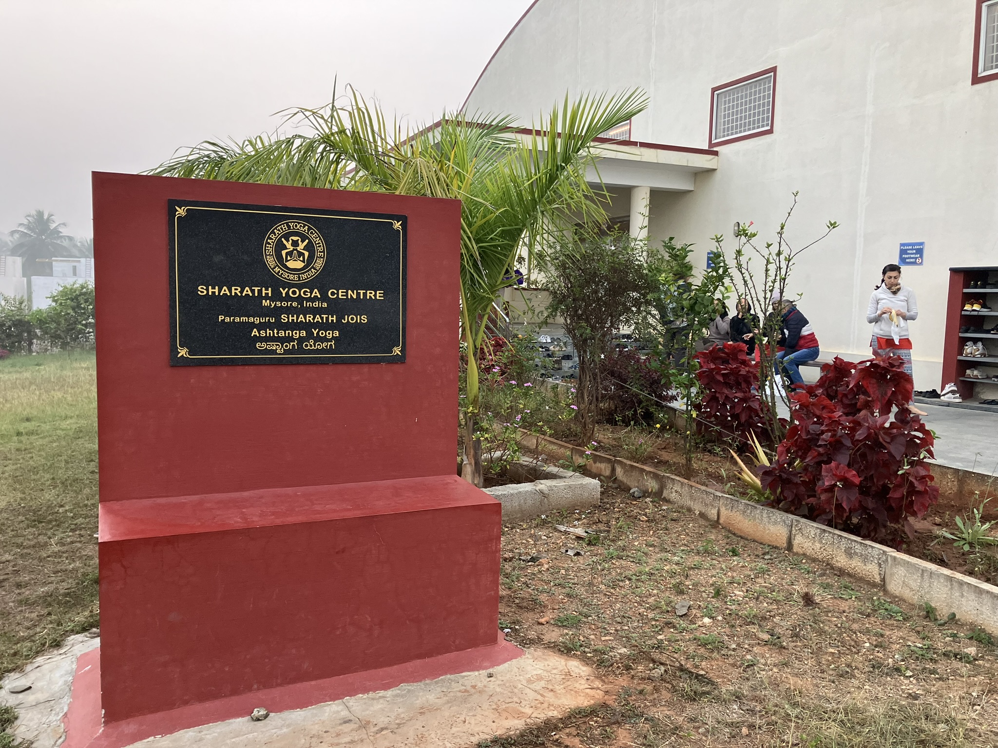 A sign for Sharath Yoga Center that names Sharath Jois as the Paramaguru.